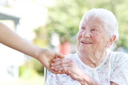 An elderly woman receives a helping hand